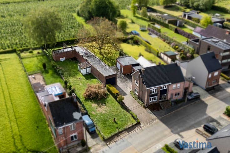 Woning met opslagruimte en grond op strategische ligging