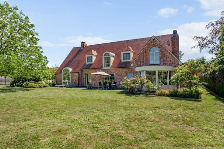 Classic villa with a view of meadows and a horse stable.