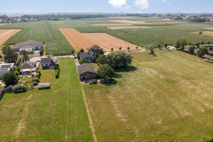 Villa met grote loods, omgeven door groen